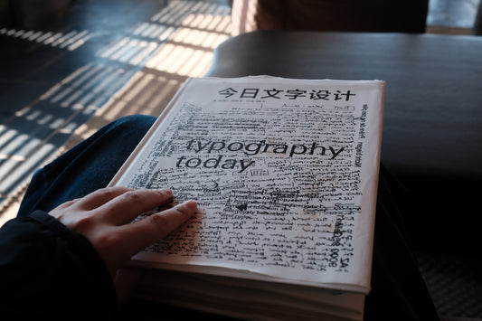 A person holding a book titled typography today
